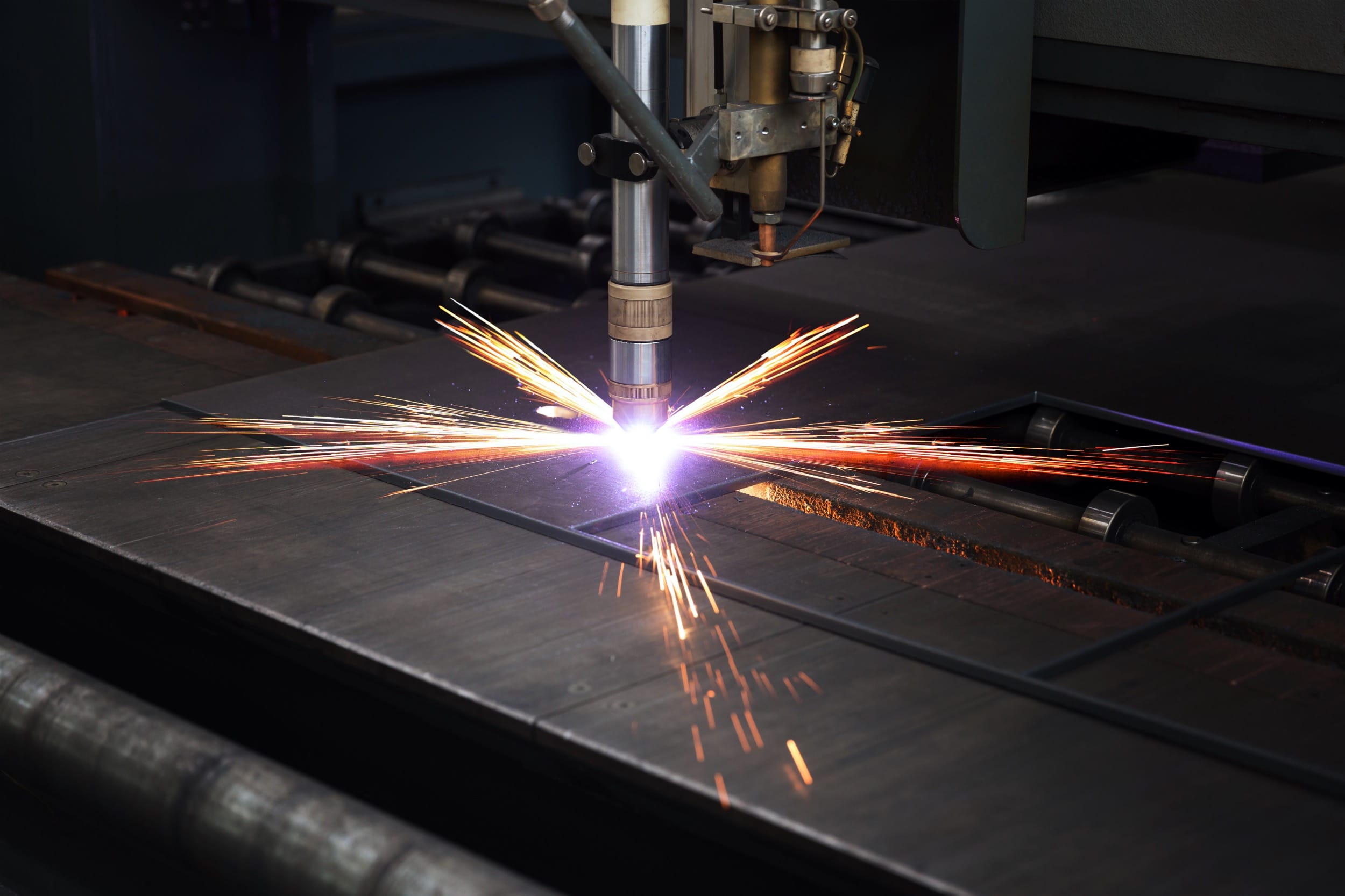 CNC plasma cutter cutting through a steel plate with bright sparks during precision metal fabrication at Riteweld Engineering.