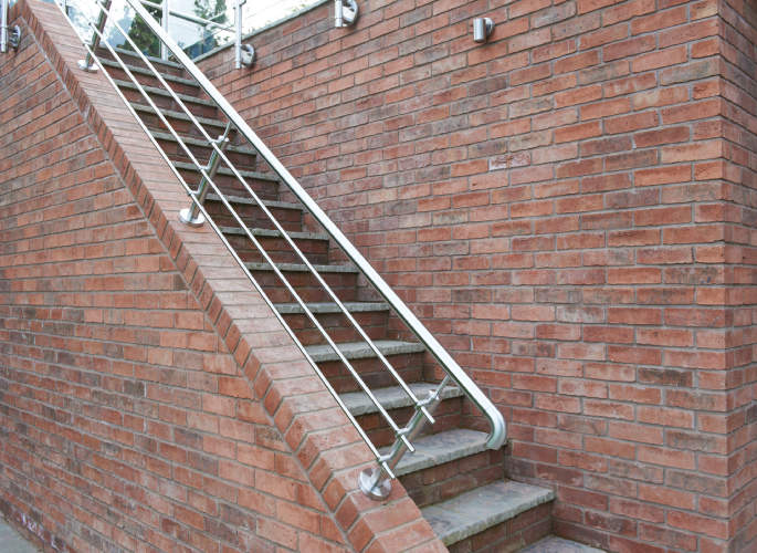 Stainless steel wire balustrade fitted to an outdoor brick staircase, installed by Riteweld Engineering