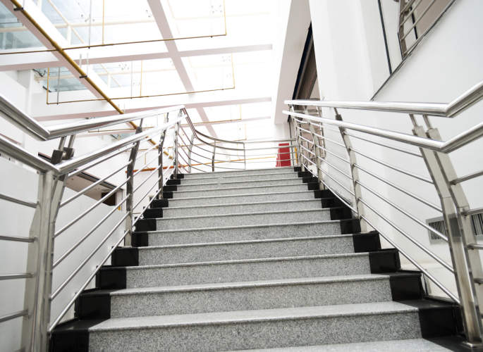Internal staircase fitted with stainless steel wire balustrades, installed by Riteweld Engineering in a modern commercial building.