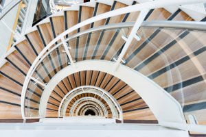 Curved helical staircase with glass balustrades and steel framing, custom fabricated by Riteweld Engineering.