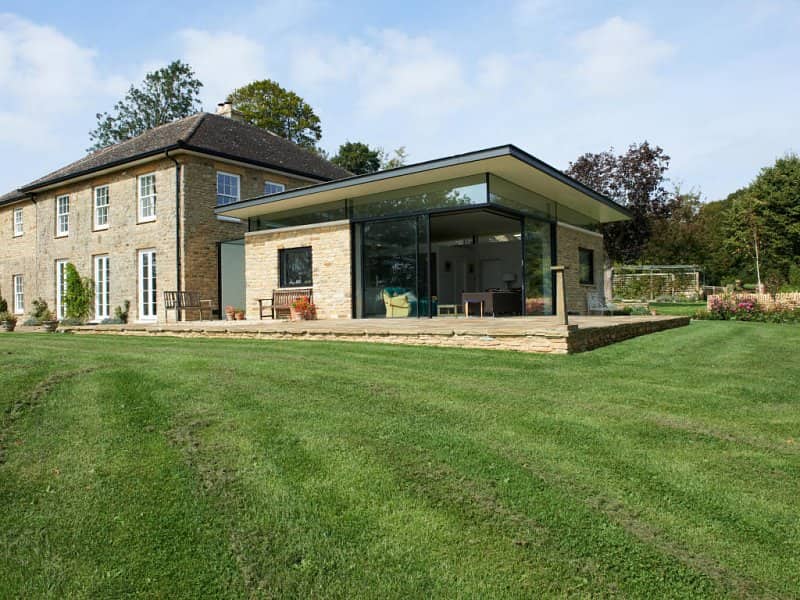 View of a traditional stone house with a modern glazed extension in North Aston, Oxfordshire, featuring structural steelwork by Riteweld Engineering.