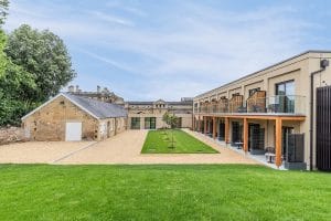 Glass balustrade and timber screening installed by Riteweld Engineering at a luxury Cotswolds hotel, featuring a landscaped courtyard and modern architectural detailing.