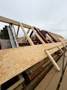 SIPs roof panels installed onto steel roof frames and timber rafters on a residential construction project.
